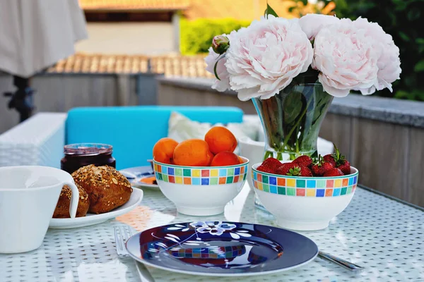 Mesa de pequeno-almoço com pão, frutas frescas e morangos e café servido no terraço balkony ou hotel na manhã de verão para o almoço romântico casal. — Fotografia de Stock