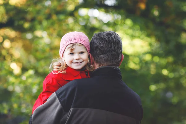 행복 한 어린 아버지가 귀여운 귀여운 아기 딸을 키우고 가족 사진을 함께 찍고 있습니다. 가을 숲이나 공원에 예쁜 여아와 함께 있는 중년 남자. 밖에 어린아이가 있는 아빠가 안아 주고 있어요. 사랑, 유대 — 스톡 사진