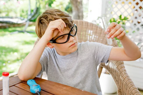 Grabben gör kemiska experiment i laboratoriet i skolan. Barn med skyddsglasögon studie med pipett släppa vätska till provröret, kaukasisk, biokemi. Kemilektioner. Sommarskola. — Stockfoto