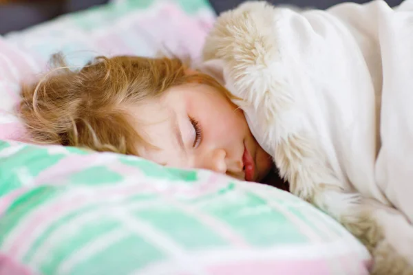 Søt liten småbarnsjente som sover i senga. Trøtt barnehagebarn drømmer, sunn søvn av barn om dagen. – stockfoto