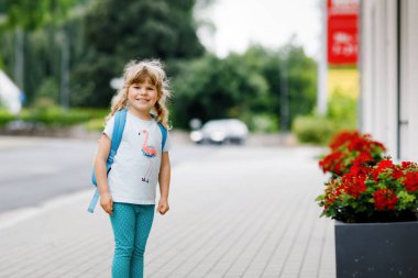 Anaokuluna giden tatlı küçük bir kız. Sağlıklı bir çocuk kreşe ve anaokuluna doğru yürüyor. Şehir caddesinde, açık havada sırt çantalı mutlu bir çocuk. Şehir, trafik, okul yolunda güvenlik..