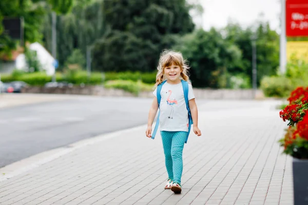 可爱的学龄前小女孩要去上幼儿园。健康的幼儿步行到托儿所和幼儿园。快乐的孩子背着背包在城市街道上，户外。城市，交通，学校路上的安全. — 图库照片