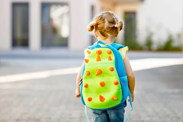 Söt liten söt liten flicka på sin första dag går till lekskolan. Friska vackra baby promenader till förskola och förskola. Lyckligt barn med ryggsäck, oigenkännligt ansikte. — Stockfoto