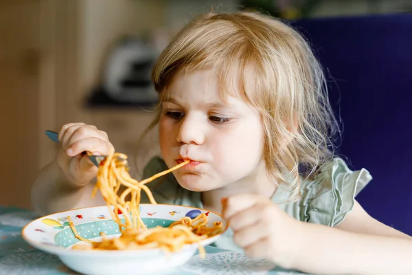 Entzückende Kleinkind Mädchen essen Pasta-Spaghetti mit Tomaten-Bolognese mit Hackfleisch. Glückliches Vorschulkind isst zu Hause, drinnen, frisch gekochte gesunde Mahlzeit mit Nudeln und Gemüse. — Stockfoto