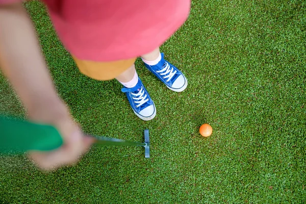 Cute preschool girl playing mini golf with family. Happy toddler child having fun with outdoor activity. Summer sport for children and adults, outdoors. Family vacations or resort. — Stock Photo, Image