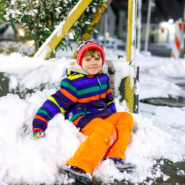 Niño divertido en ropa colorida jugando al aire libre durante las nevadas. Ocio activo con niños en invierno en días fríos nevados. Niño feliz en el mercado de Navidad en Alemania. — Foto de Stock