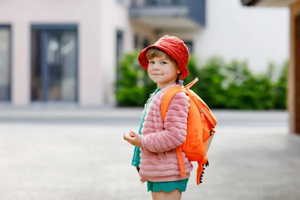 Милая маленькая дошкольница ходит в детскую школу. Здоровый ребенок, идущий в детскую школу и детский сад. Счастливый ребенок с рюкзаком на городской улице, на улице. — стоковое фото