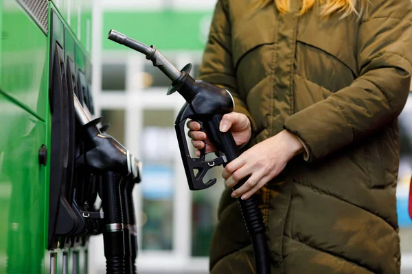 Primer plano de las manos de la mujer en la gasolinera de autoservicio, mantenga la boquilla de combustible y repostar el coche con gasolina, diesel, gas. Cierre de llenado automático con gasolina o bencina. Autoservicio bomba de gas — Foto de Stock