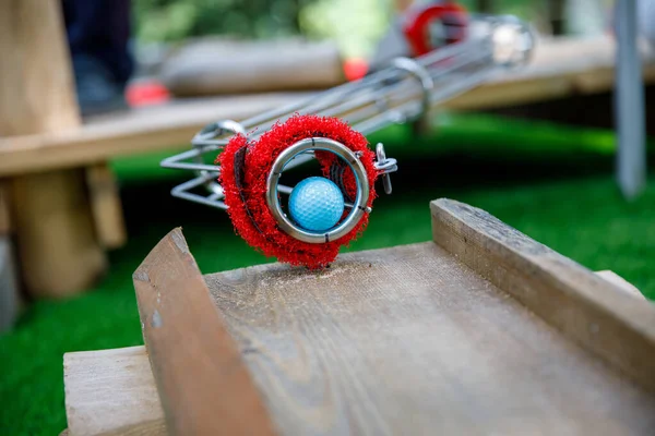 Gros plan de balle pour jouer au mini golf en famille. Familles s'amusant avec l'activité de plein air. Sport d'été pour enfants et adultes, en plein air. Vacances en famille ou station balnéaire. — Photo