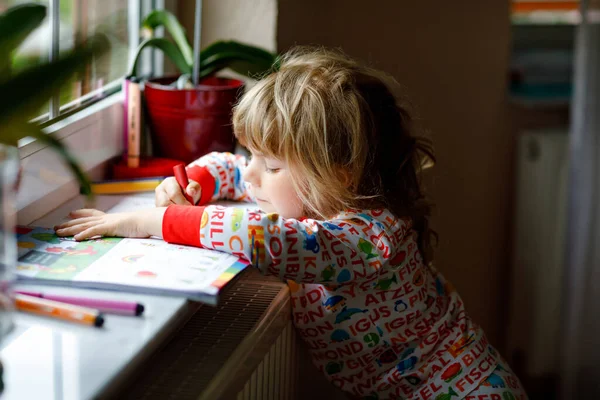 Petite fille tout-petit peinture avec crayons de couleurs crayon pendant la maladie de quarantaine de coronavirus pandémique. Les enfants peignent et dessinent, les arts créatifs et le concept éducatif. Joyeux enfant — Photo