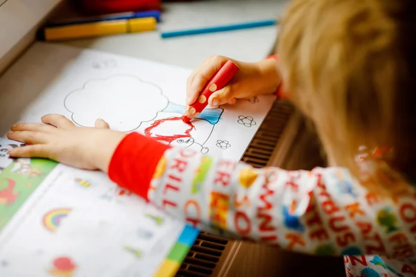 Kleine peuter meisje schilderen met krijt kleuren potloden tijdens pandemische coronavirus quarantaine ziekte. Kinderen schilderen en tekenen, creatieve kunsten en onderwijs concept. Gelukkig kind — Stockfoto