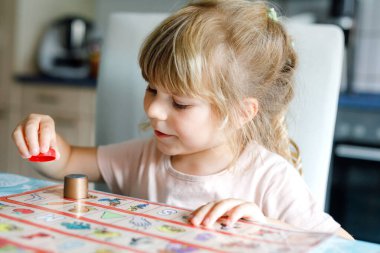 Küçük sevimli kız iskambil oynuyor. Mutlu sağlıklı çocuk hafızasını eğitiyor, düşünüyor. Salgın Coronavirus covid karantina hastalığı sırasında çocuğun evde dinlenmesi ve eğitilmesi