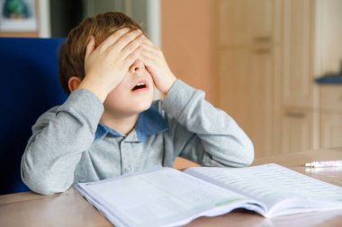 Corona salgınından dolayı karantina zamanında ödev yapan liseli çocuk. Ağlayan ve üzgün çocuk evde kalmak sinir bozucu..