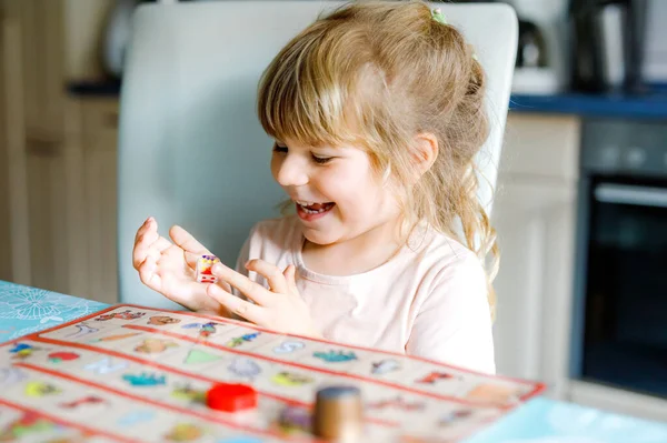 Adorable linda niña jugando juego de cartas imagen. Feliz niño sano entrenando la memoria, pensando. Creativo en interiores ocio y educación de los niños durante la pandemia coronavirus covid enfermedad de cuarentena — Foto de Stock
