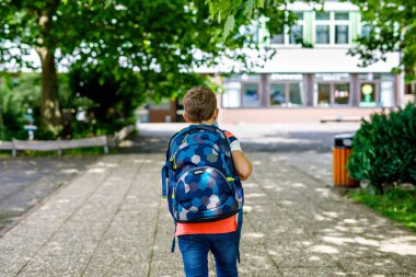 Çantası olan küçük mutlu çocuk. Ortaokul ya da liseye giden okul çocuğu. Okul bahçesinde sağlıklı, sevimli bir çocuk. Okula dönelim. Arkaplanda inşa ediliyor.