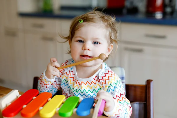 Urocza, śliczna dziewczynka bawiąca się drewnianą zabawką edukacyjną w domu. Szczęśliwy podekscytowany dziecko maluch nauczyć się grać kolorowe tęczowe ksylofon. Wczesna edukacja, zajęcia dla dzieci. — Zdjęcie stockowe