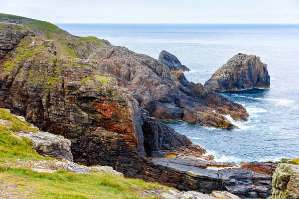 Paesaggio accidentato a Malin Head, contea di Donegal, Irlanda. Spiaggia ruvida con scogliere, verde terra rocciosa con pecore nella nebbiosa giornata nuvolosa. — Foto Stock