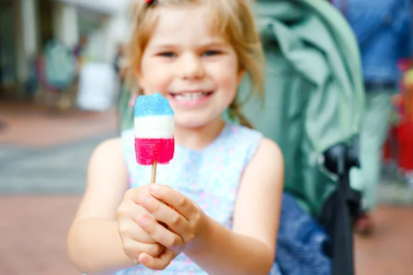 Klein kleuterschoolmeisje met lolly. Schattig gelukkig peuter kind likken zoete suiker lolli. Gelukkig kind met snoep. — Stockfoto