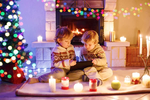 Due ragazzi bambino carino, gemelli biondi che giocano con il nuovo regalo tablet. Famiglia che celebra le vacanze di Natale — Foto Stock