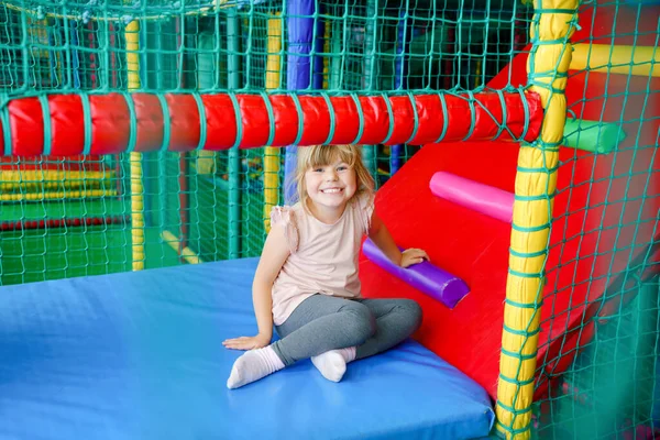 Petite fille active jouant dans une aire de jeux intérieure. Joyeux enfant d'âge préscolaire joyeux grimper, courir, sauter et s'amuser avec des boules en plastique colorées. Activité intérieure pour les enfants. — Photo