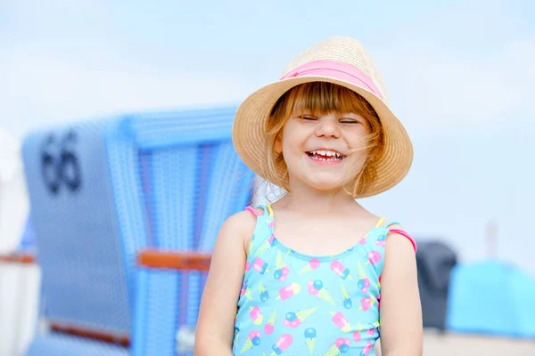 Portrait de fille préscolaire en maillot de bain coloré et chapeau de paille. Mignon enfant heureux tout-petit en vacances en famille sur la mer. Bonheur, été et voyage avec enfants concept. — Photo