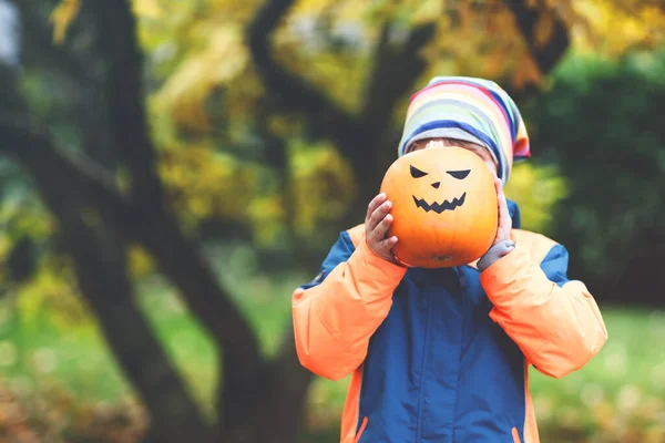 Niño lindo feliz con linterna de calabaza de halloween en autu — Foto de Stock