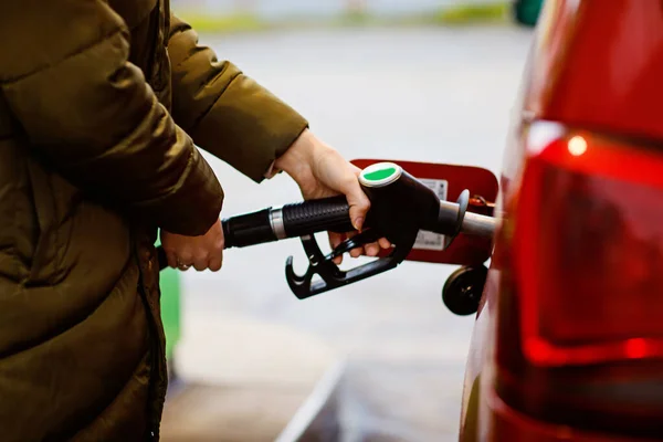 Primer plano de las manos de la mujer en la gasolinera de autoservicio, mantenga la boquilla de combustible y repostar el coche con gasolina, diesel, gas. Cierre de llenado automático con gasolina o bencina. Autoservicio bomba de gas — Foto de Stock