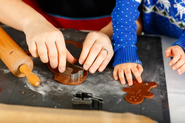 Close-up de mãos de pequeno menino pré-escolar e pai assar biscoitos de gengibre. De perto do pai e do filho, homem de camisola de Natal. Cozinha decorada para o Natal. Atividade familiar de Natal — Fotografia de Stock