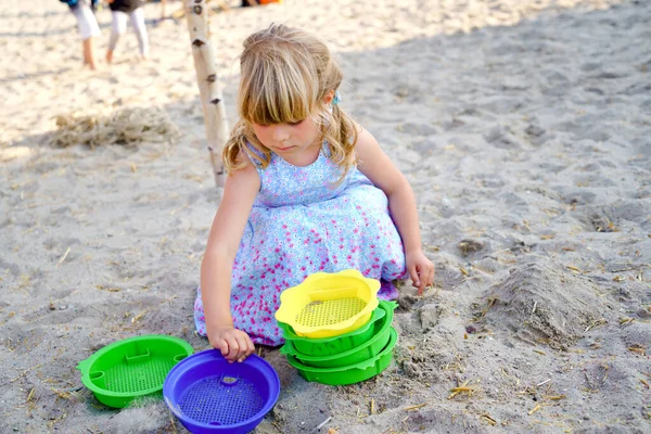 Little preschool girl playing with sand toys on the beach. Cute happy toddler child on family vacations on the sea. Active child having fung on Baltic Sea. Outdoor activity for children — Stock Photo, Image