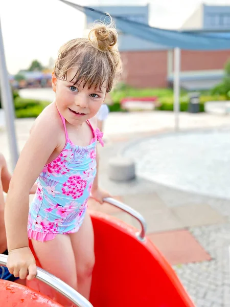 Dziewczynka z przedszkola pluskająca się w odkrytym basenie w ciepły letni dzień. Szczęśliwy zdrowy maluch cieszący się słoneczną pogodą w miejskim basenie publicznym. Aktywność dzieci na świeżym powietrzu z wodą. — Zdjęcie stockowe