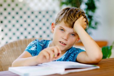 Çalışkan, mutlu okul çocuğu Corona salgınından dolayı karantina zamanında ödev yapıyor. Kalemle yazan sağlıklı bir çocuk, evde kalıyor. Evde eğitim kavramı