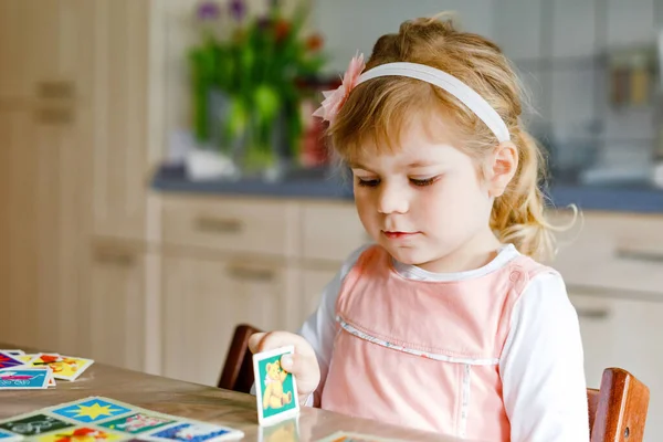 Roztomilé roztomilé batole dívka hraje hru s obrázkem karty. Šťastný zdravý dětský trénink paměti, přemýšlení. Kreativní vnitřní volný čas a vzdělávání dětí během pandemické koronavirové covid karanténní choroby — Stock fotografie