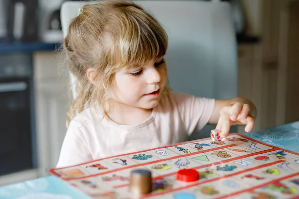 Adorable linda niña jugando juego de cartas imagen. Feliz niño sano entrenando la memoria, pensando. Creativo en interiores ocio y educación de los niños durante la pandemia coronavirus covid enfermedad de cuarentena — Foto de Stock