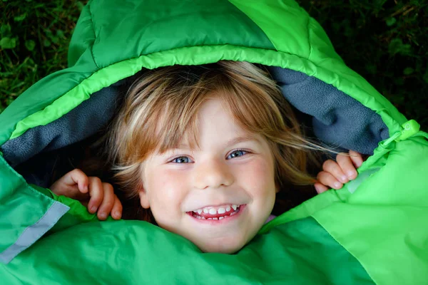 Niña preescolar en el campamento saco de dormir. Actividad al aire libre con niños en verano. Campamento de diversión y aventura, vacaciones en familia y amigos o viaje de fin de semana. Retrato de niño con linterna. — Foto de Stock