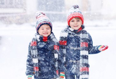 Mutlu çocuklar kışın karla eğleniyor.
