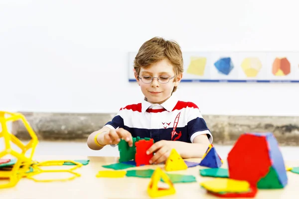 Boldog fiú szemüveges szórakozás épület és létrehozása geometriai alakok, tanulás matematika és geometria — Stock Fotó