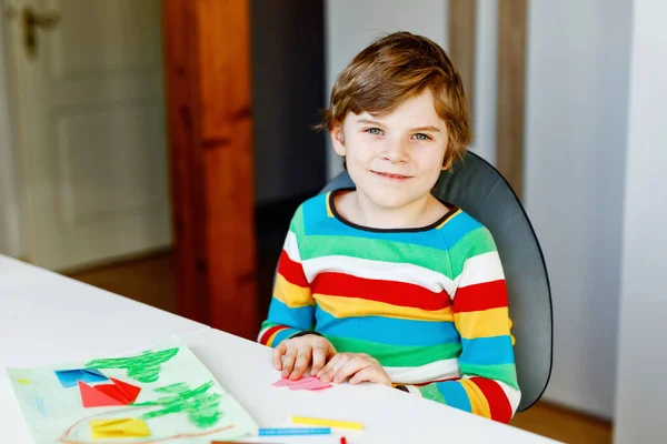 Kleine jongen maken papier origami tulp bloemen voor een ansichtkaart voor moeders dag of verjaardag. Schattig kind van de lagere school die handwerk doet — Stockfoto