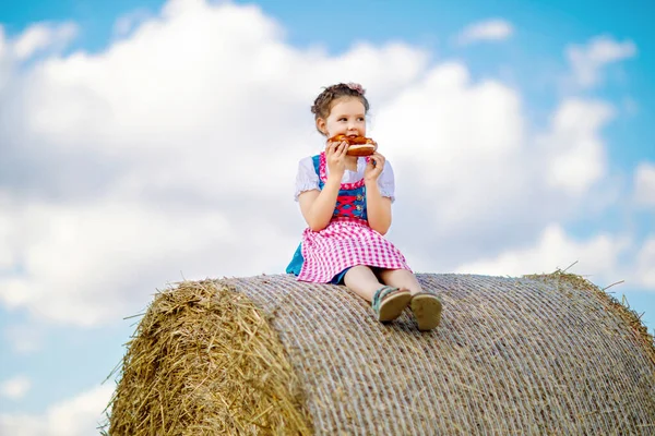 Linda niña en traje tradicional bávaro en el campo de trigo —  Fotos de Stock