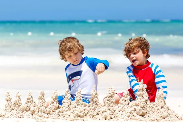 Twee jongens die zandkasteel bouwen op het tropische strand van Playa del Carmen, Mexico — Stockfoto