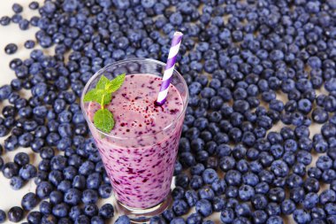 Blueberry smoothie bir cam kavanoza bir saman ve ince dal nane