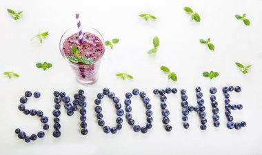Blueberry smoothie bir cam kavanoza bir saman ve ince dal nane