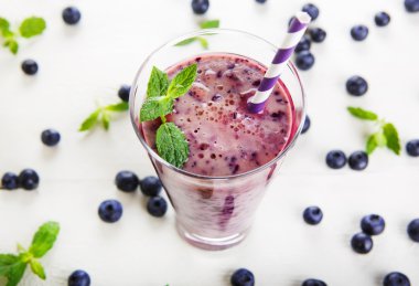Blueberry smoothie bir cam kavanoza bir saman ve ince dal nane
