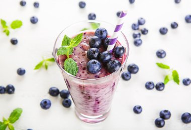 Blueberry smoothie bir cam kavanoza bir saman ve ince dal nane