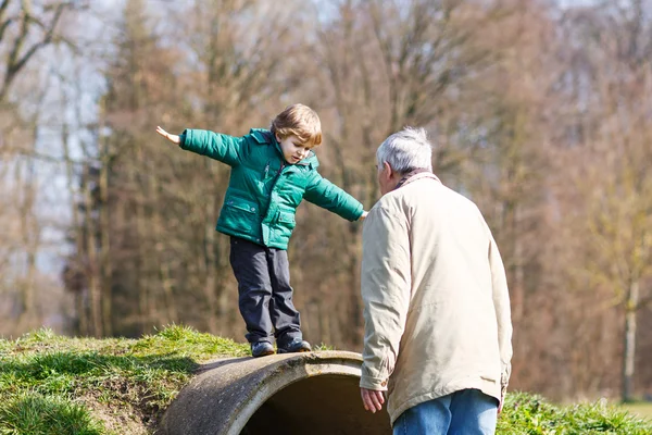 Glad farfar och hans lilla barnbarn att ha roligt, utomhus — Stockfoto