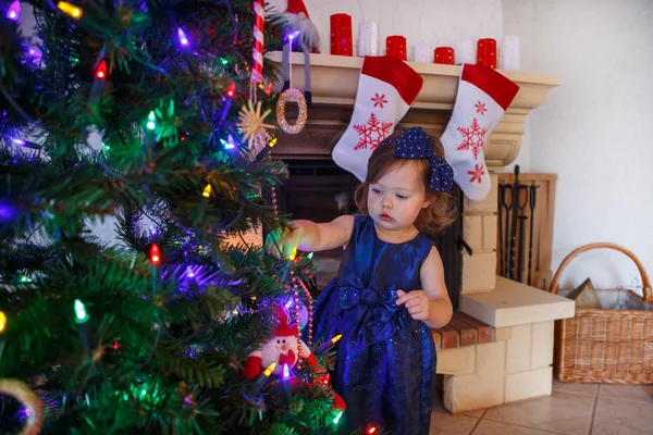 Little girl being happy about christmas tree and lights — Stock Photo, Image