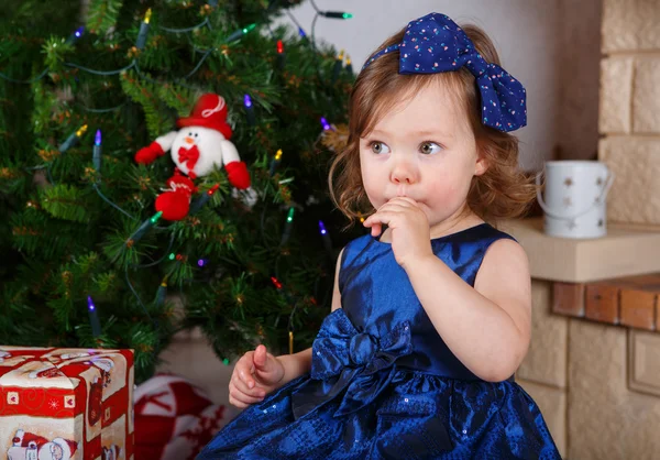 Kleines Mädchen mit Lutscher und Weihnachtsbaum und Dekoration — Stockfoto