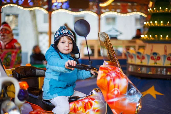 Adorable little child on a carousel at Christmas funfair or mark — Stock Photo, Image