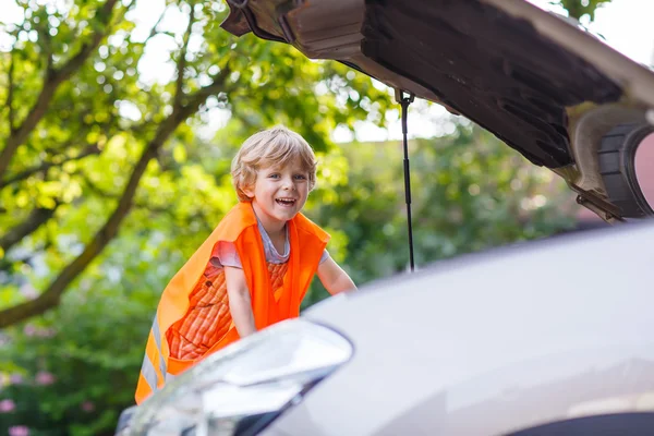 Liten pojke tittar på motor i familjens bil — Stockfoto
