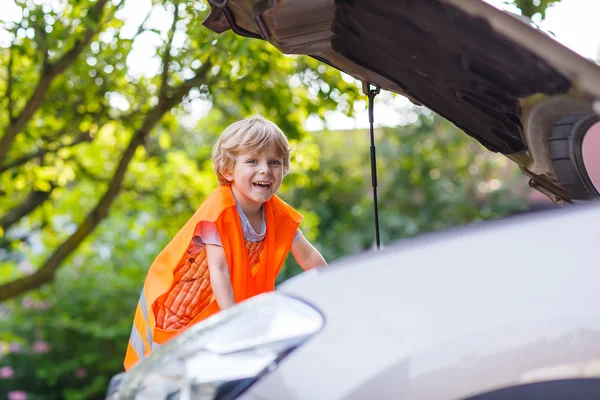 Petit garçon regardant le moteur dans la voiture familiale — Photo