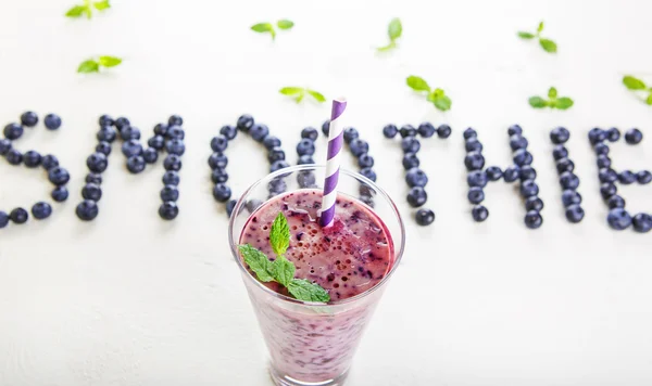 Blueberry smoothie in a glass jar with a straw and sprig of mint — Stock Photo, Image